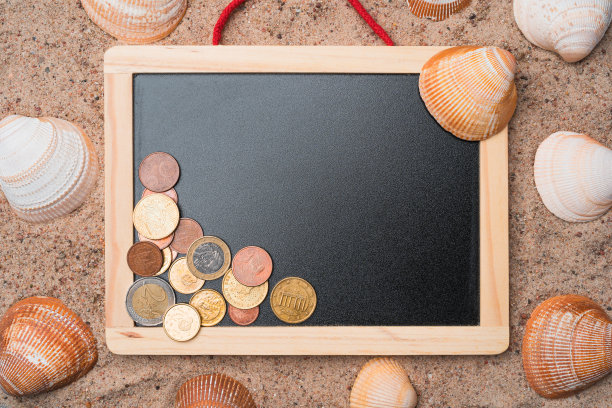 黑板上的沙子上有贝壳和欧元硬币。图片下载