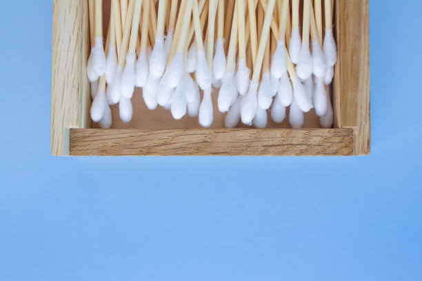 在蓝色的背景上，竹棉棒在可重复使用的木箱上的特写。Copyspace为您的设计，零浪费的概念图片下载