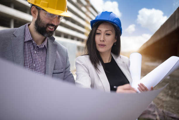 多民族工程师工人与图纸在建筑工地库存照片图片下载