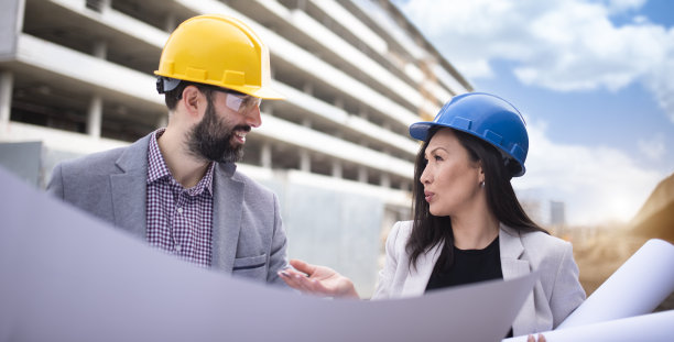 多民族工程师工人与图纸在建筑工地库存照片图片下载