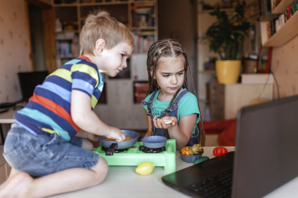 孩子们在笔记本电脑屏幕上观看美食博客视频，并在大师厨师中玩耍图片下载