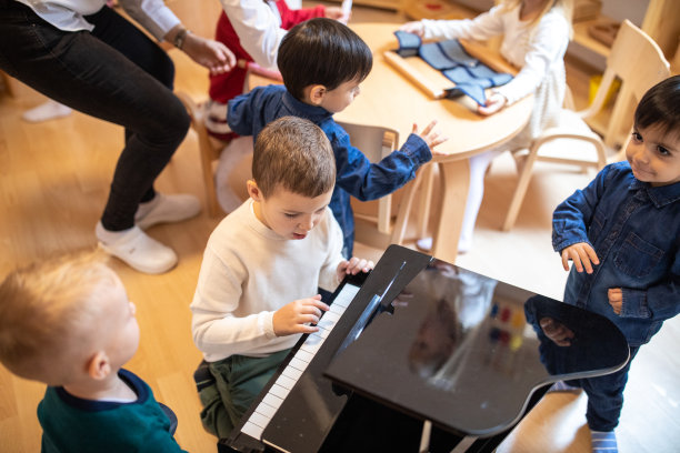 孩子们在托儿所的游戏室里弹奏迷你钢琴图片下载