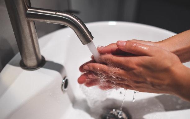 在水龙头下洗手的女人图片下载