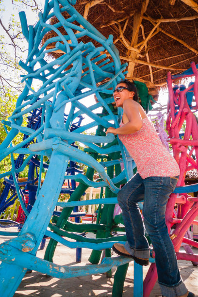 女人爬上了蓝色和粉色的木椅图片下载