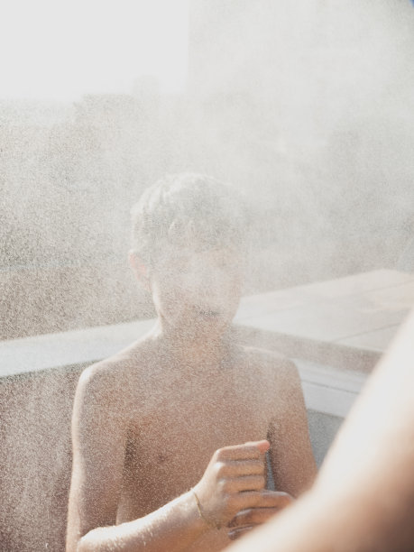 欢快的年轻男性正在室外阳台上用软管淋浴图片下载