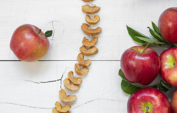 干苹果切片水果与成熟的新鲜红苹果在木制的乡村背景，自制干果的概念图片下载