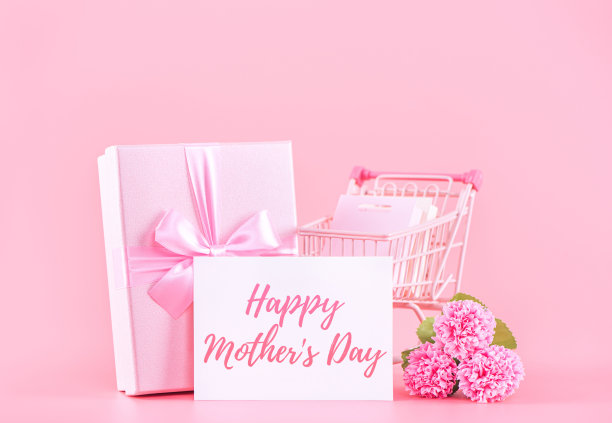 母亲节节日礼品设计理念，粉色康乃馨花束与包装盒隔离在浅粉色背景上，复制空间。图片下载