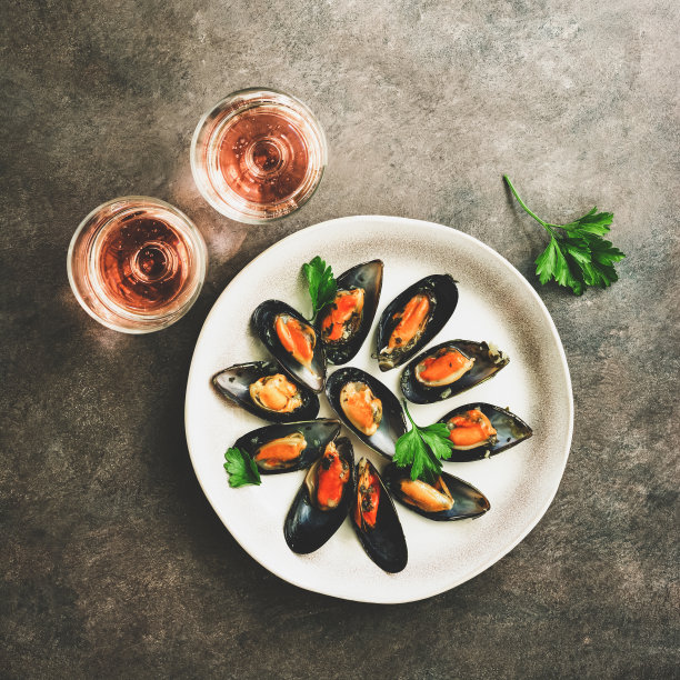 贻贝配香料，两杯粉色气泡酒，深色乡村背景。广场的照片。俯视图，平放，复制空间。图片下载