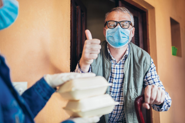 一个十几岁的女孩正在给一位老人送一些杂货。图片下载