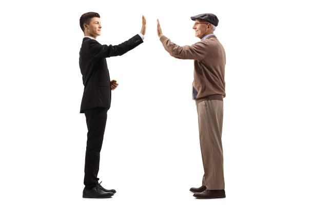 一个穿着西装的年轻人用击掌的姿势问候一位老人图片下载