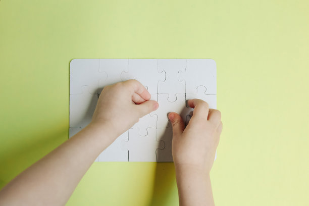 蔡尔兹把最后一块白色拼图放在黄色的背景上图片下载