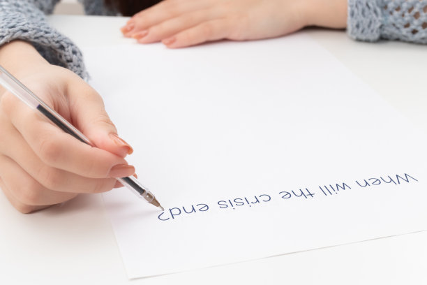 金融崩溃和失业。女性的手写在一张纸上的时候危机就会结束图片下载