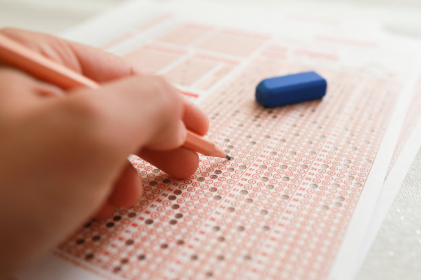 在学校，学生们用铅笔在答题纸上做测验图片下载