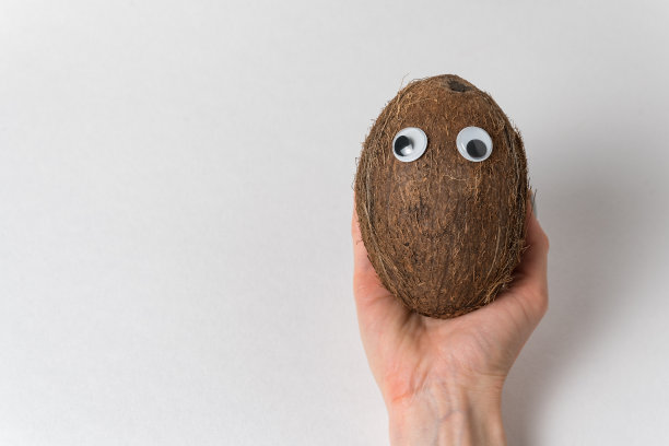 手持白色背景上的google眼睛椰子。疯狂的螺母。本空间图片下载