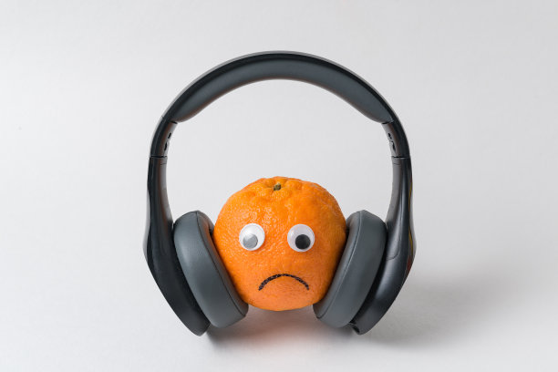 橙色的，带着大大的耳机的悲伤表情。太多噪音概念图片下载