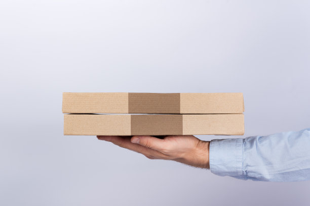 男人手里拿着披萨盒。白色背景。侧视图。快递送货图片下载