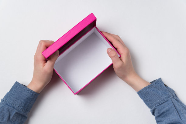 打开孩子们手中的粉色纸盒。俯视图，白色背景。图片下载