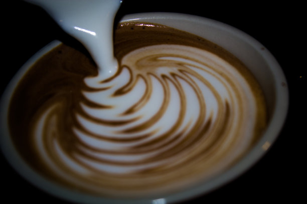 黑色背景上的蒸汽牛奶拉花艺术图片下载