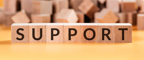 支持词由木制立方体在黄色的背景上模糊的立方体。图片下载