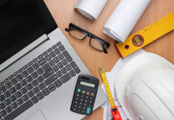 建筑师的创意布局与卷轴图纸，建筑项目计划，工程工具和文具，桌上笔记本电脑，工作空间。前视图。平躺图片下载