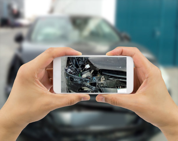 一名男子在拍摄他损坏的汽车图片下载