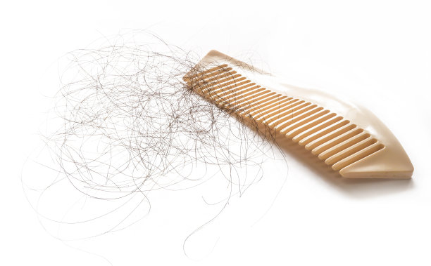 黑色的头发脱落在白色的塑料梳孤立在白色的背景图片下载