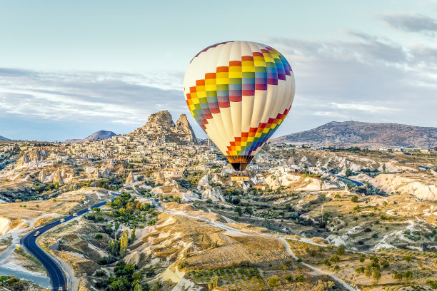 明亮的单一热气球飘过高速公路，使古老的城镇相形见绌图片下载