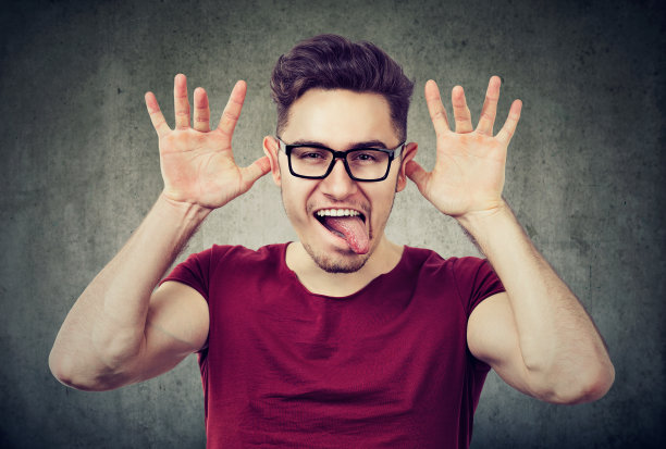 孩子气的男人对着镜头做鬼脸图片下载