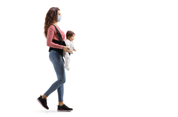 母亲与婴儿在一个载体上戴着防护医疗口罩和行走图片下载