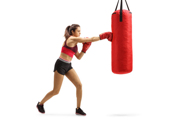 带着拳击袋锻炼的年轻女子图片下载
