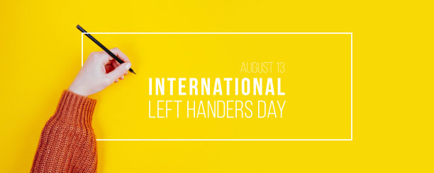 一个左撇子妇女的手里握着一支铅笔。黄色背景下的左撇子的国际概念图片下载