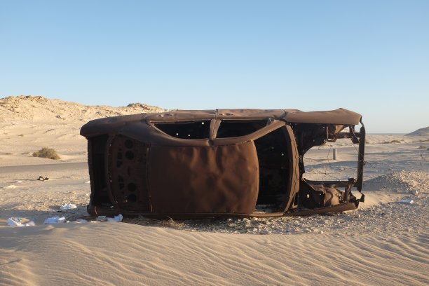 毛里塔尼亚沙漠路边生锈的废弃汽车残骸图片下载
