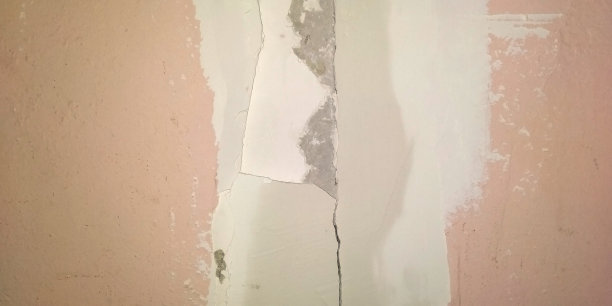 一个废弃的房子的旧裂墙的碎片特写。抽象的背景图片下载