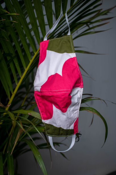 手工制作口罩。可在冠状病毒爆发导致医用口罩短缺期间使用。新型冠状病毒肺炎手里握着一个绿色的自然底色。副本的空间。图片下载