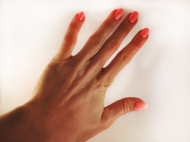 白色背景上一位女士手上的粉色指甲。图片下载