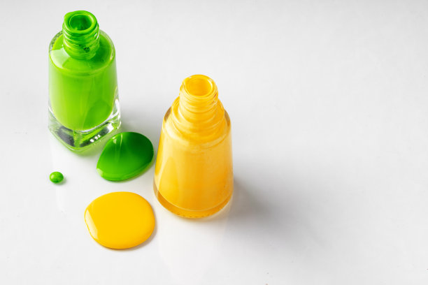 明亮颜色的指甲油瓶与滴在白色背景图片下载