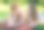 一个成年的女儿和她年迈的母亲一起躺在格子布上，互相吐着舌头。在公园户外拍摄家庭照片。图片下载