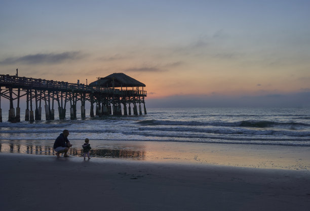 父亲和女儿享受海滩和充满活力的日出在可可海滩码头，佛罗里达中部美国图片下载