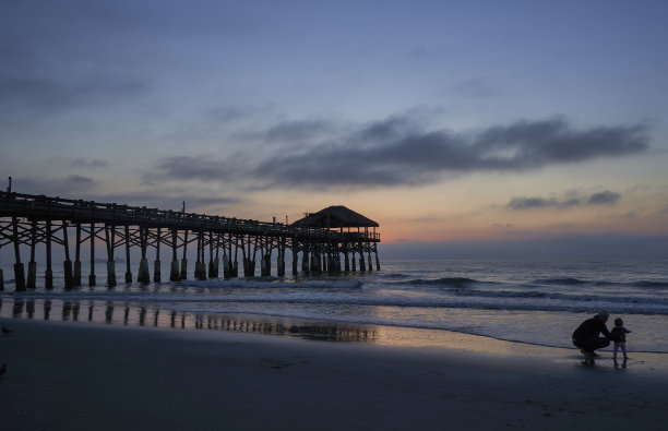 母亲和女儿享受海滩和充满活力的日出在可可海滩码头，佛罗里达中部美国图片下载