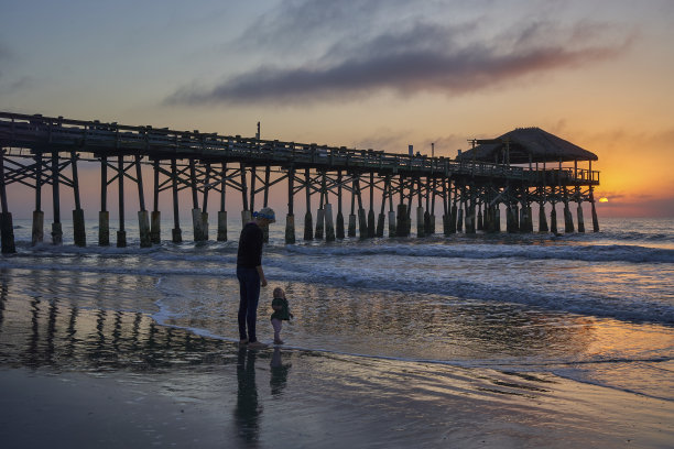 母亲和女儿享受海滩和充满活力的日出在可可海滩码头，佛罗里达中部美国图片下载