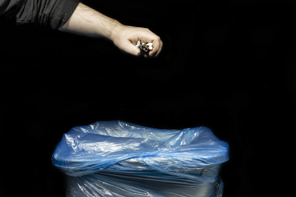 男性戒烟，手里拿着一束香烟，准备扔到垃圾桶里图片下载