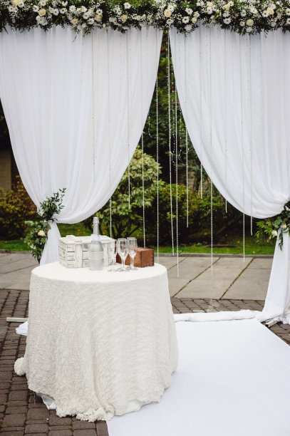 婚礼的弧线由织物和白色花朵构成的自然背景。仪式在露天举行。婚礼的假日装饰。婚礼的背景。图片区。图片下载