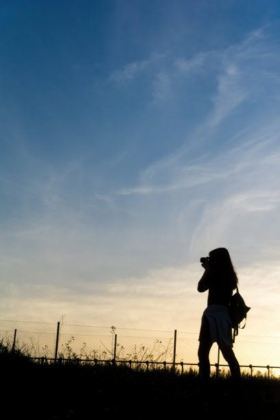 女孩在日落时拍摄大自然图片下载
