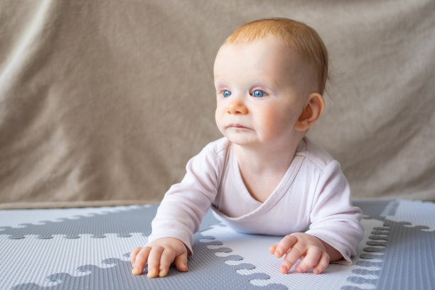 红头发的女婴躺在地板上沉思，看向别处图片下载
