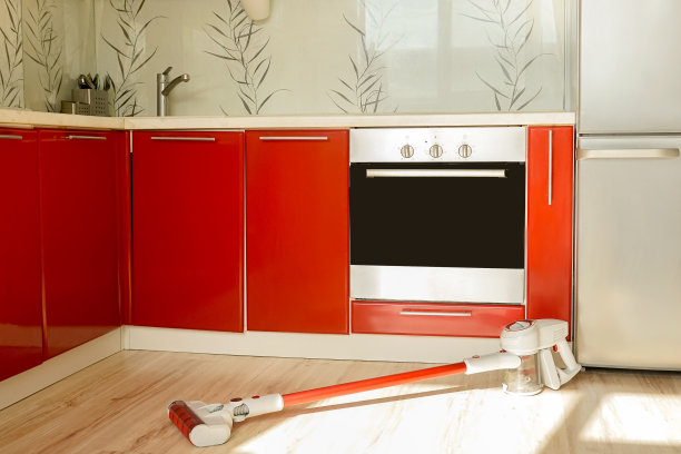 红色厨房里的红色无线吸尘器。图片下载