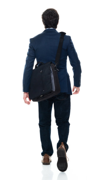 白人年轻男性商人走在前面的白色背景，穿着衬衫和拿着包图片下载