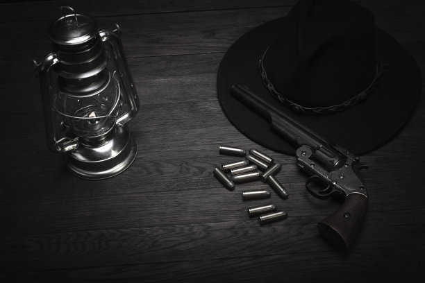 老式的西部冷风提灯和带子弹的左轮手枪图片下载