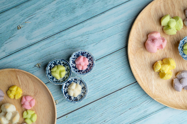 泰国传统饼干在蓝色的盘子和木制圆板与蓝色的乡村老木桌图片下载