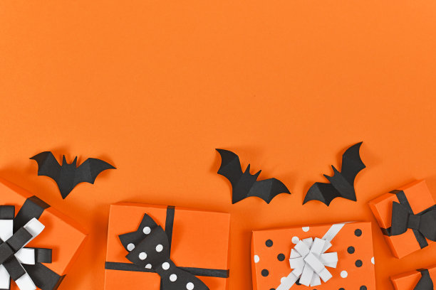 万圣节平铺着橙色，黑色和白色的季节工艺纸盒和背面纸飞行蝙蝠在空白的背景与复制空间图片下载