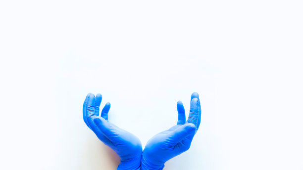 双手戴着蓝色医用手套，做出拯救的姿势。白色背景，文本复制空间图片下载
